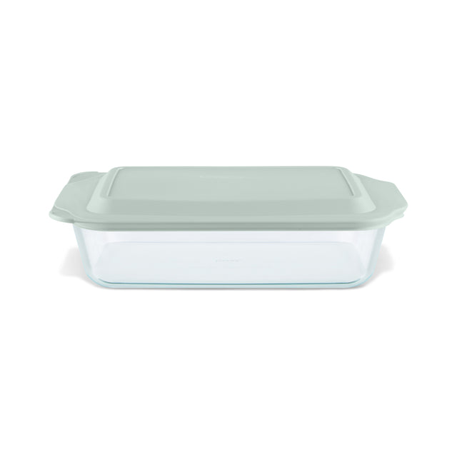 Glass baking dish with a green lid on a white background