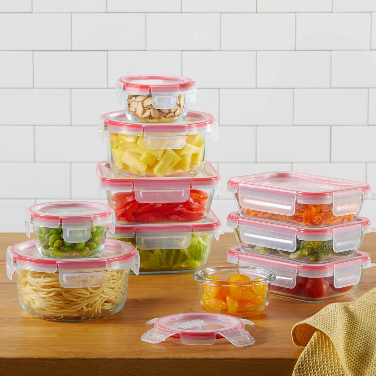 a set of pyrex glass containers with food on a wooden table