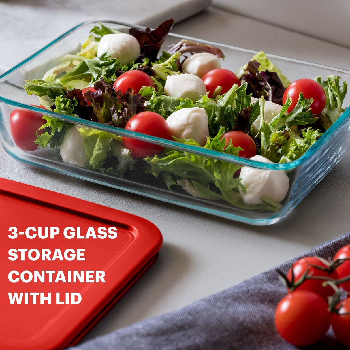 Glass storage container with salad and text '3-Cup Glass Storage Container with Lid' on a white surface.
