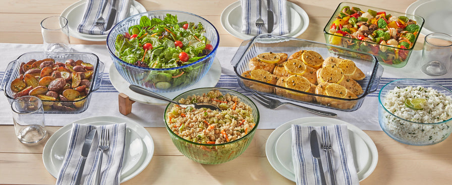 Various glass bowls and storage dishes with food on a wooden table.