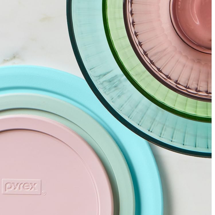 Stack of colorful Pyrex dishes on a white surface