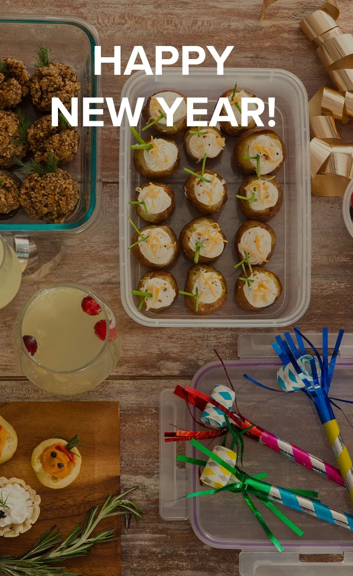 New Year's Eve party setup with food, drinks, and decorations on a wooden table.