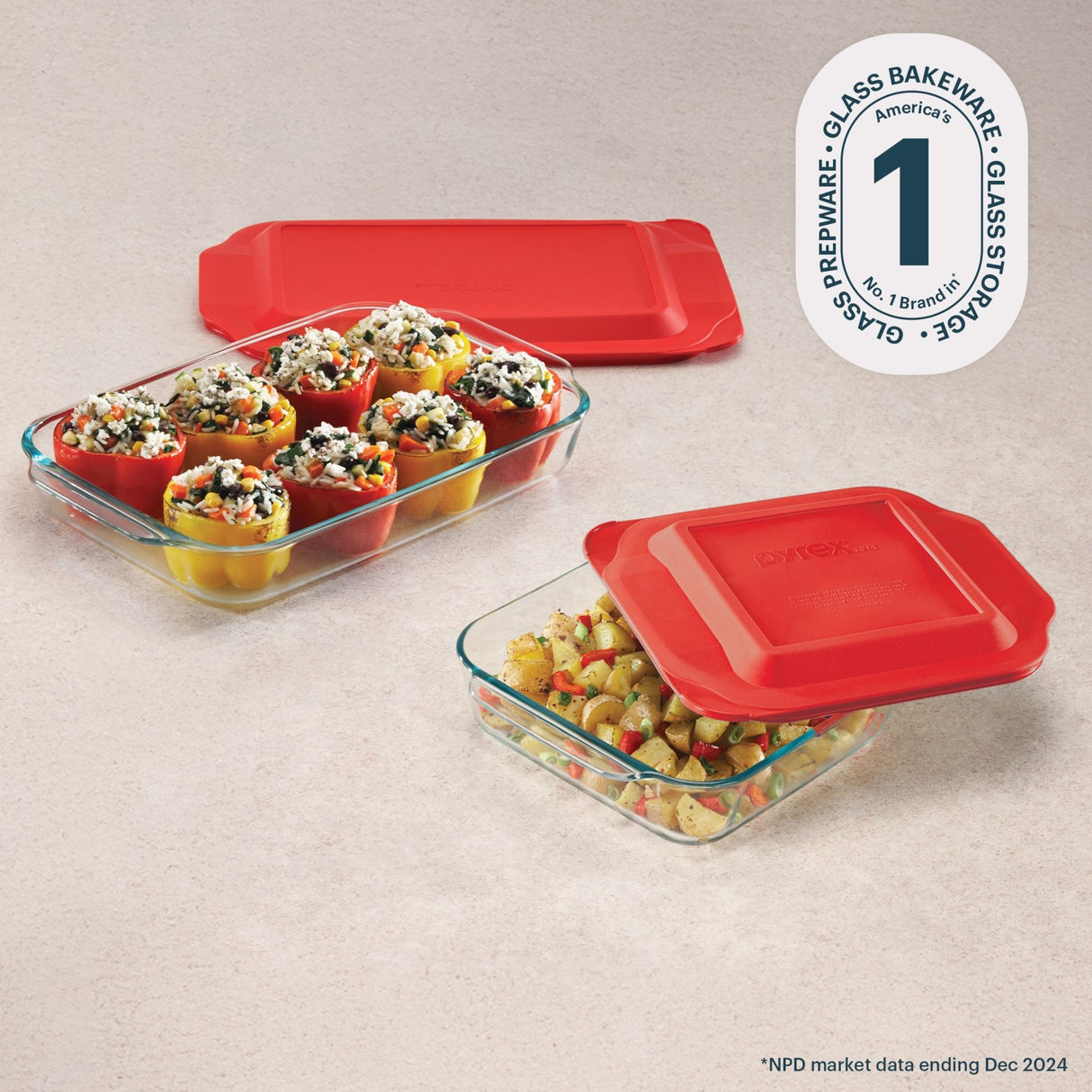 Glass bakeware set with red lids on a beige surface, featuring Pyrex branding.