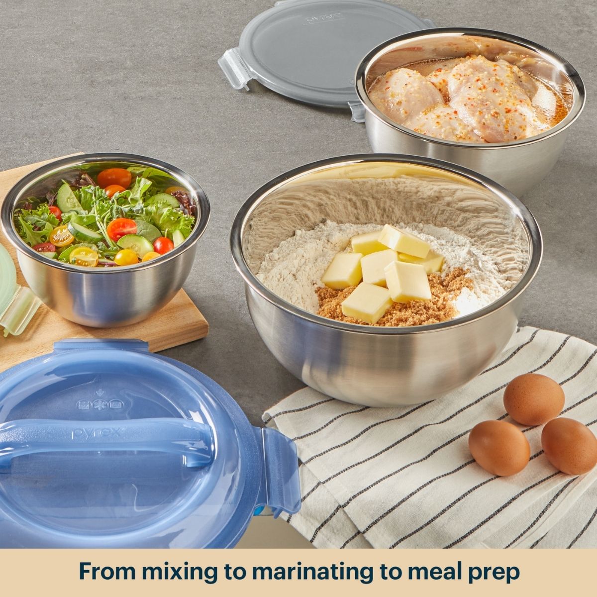 Set of stainless steel mixing bowls with various ingredients on a kitchen counter.