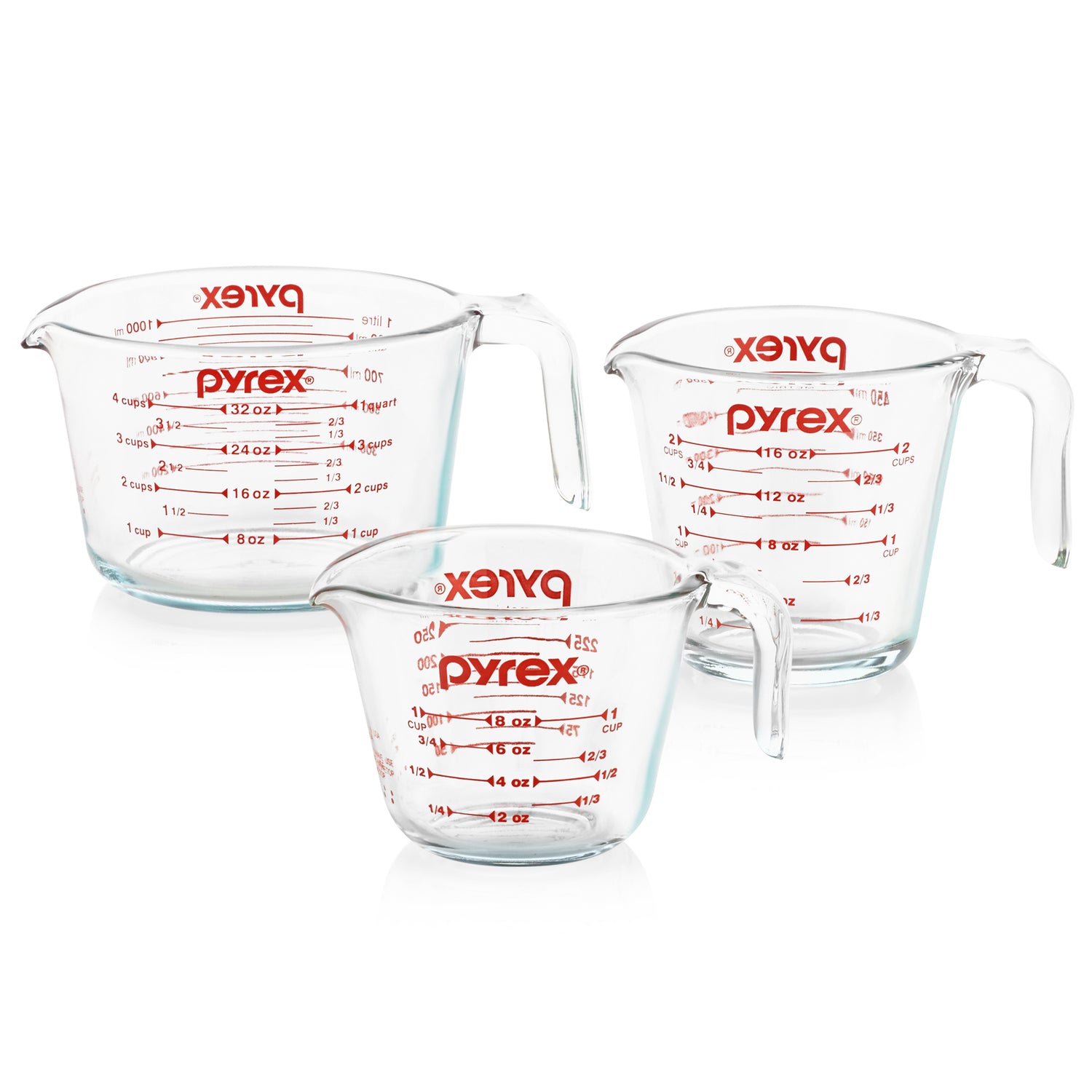 Three Pyrex measuring cups on a white background