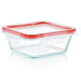 Clear glass food storage container with a red lid on a white background