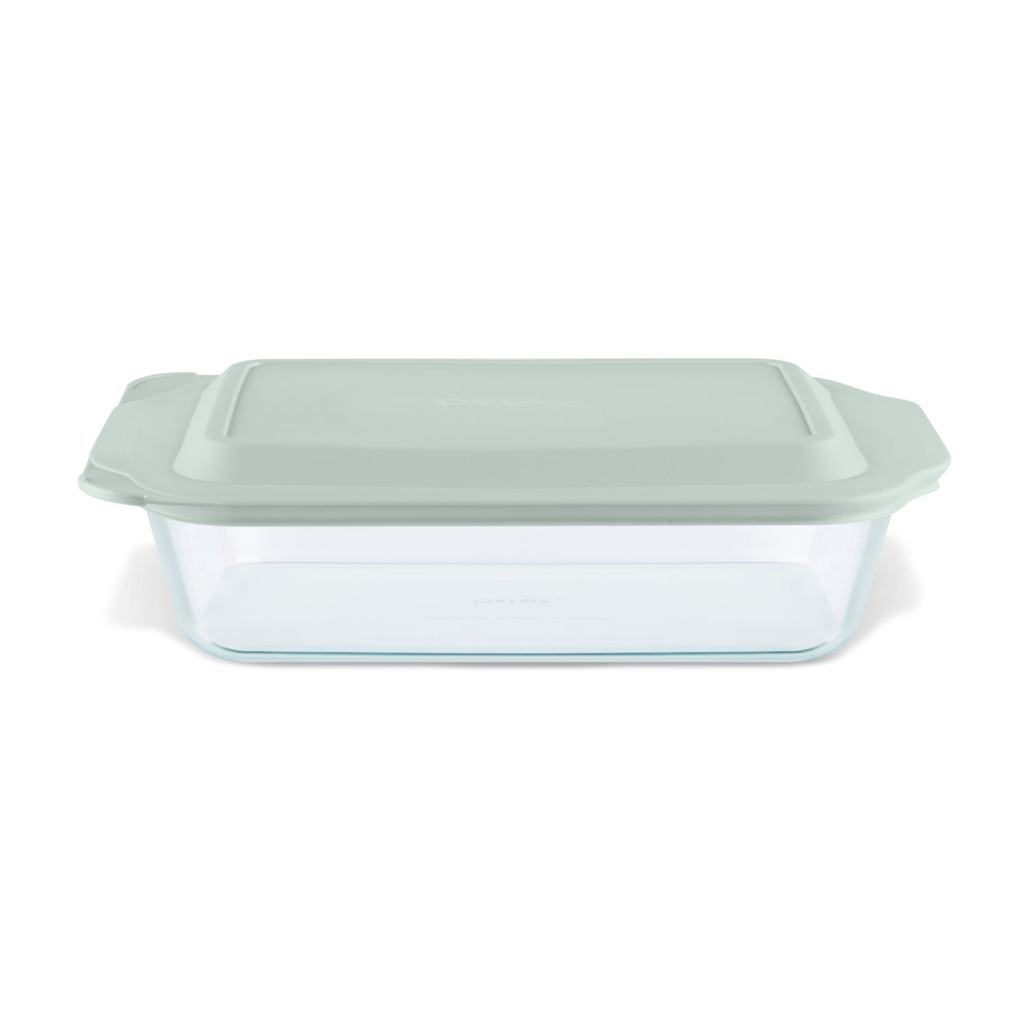 Glass baking dish with a green lid on a white background