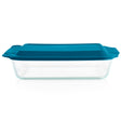 Clear glass baking dish with a blue lid on a white background