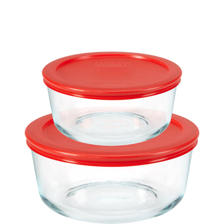 Two glass food storage containers with red lids on a white background