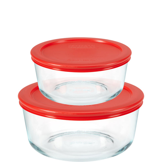 Two glass food storage containers with red lids on a white background