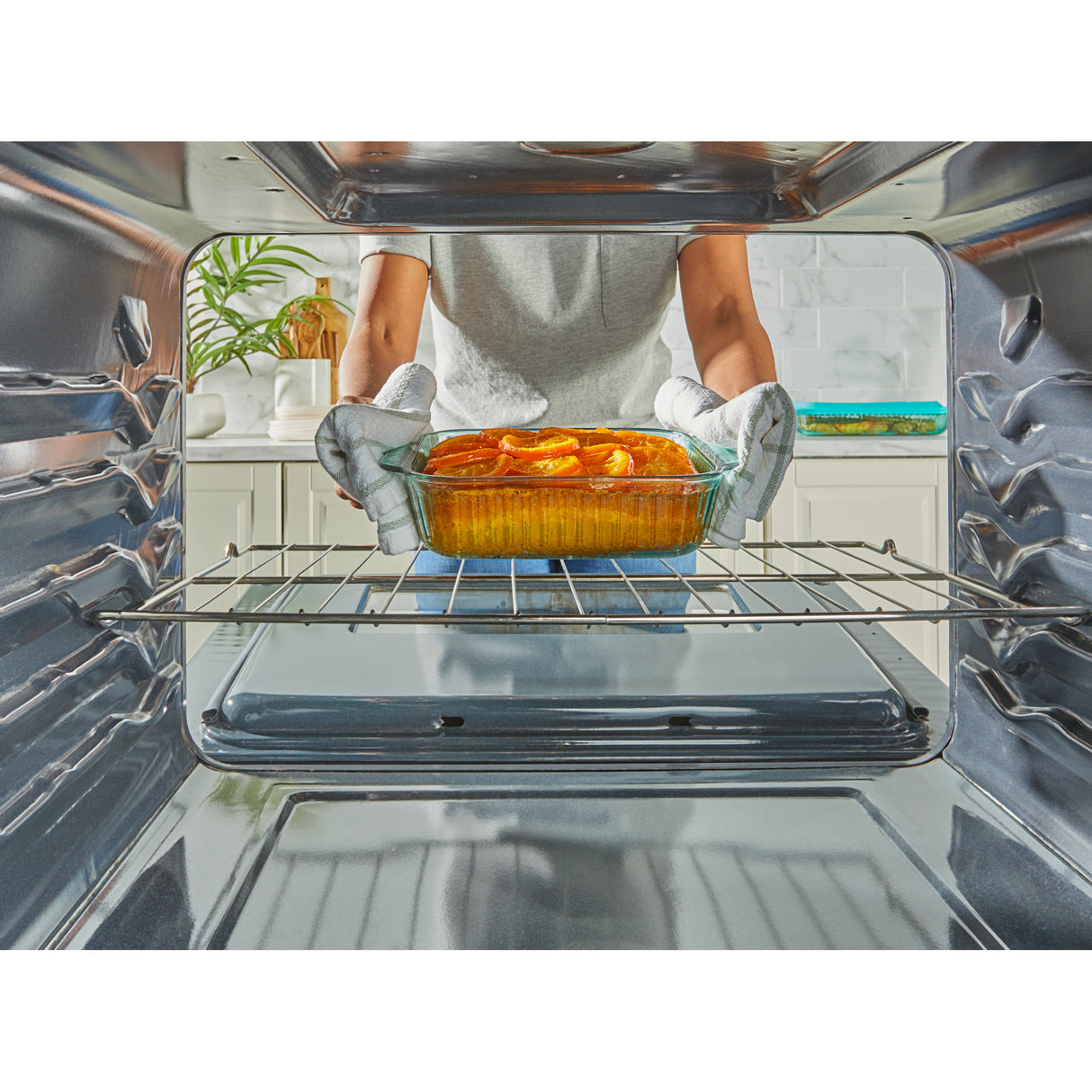 Person placing a dish into an open oven