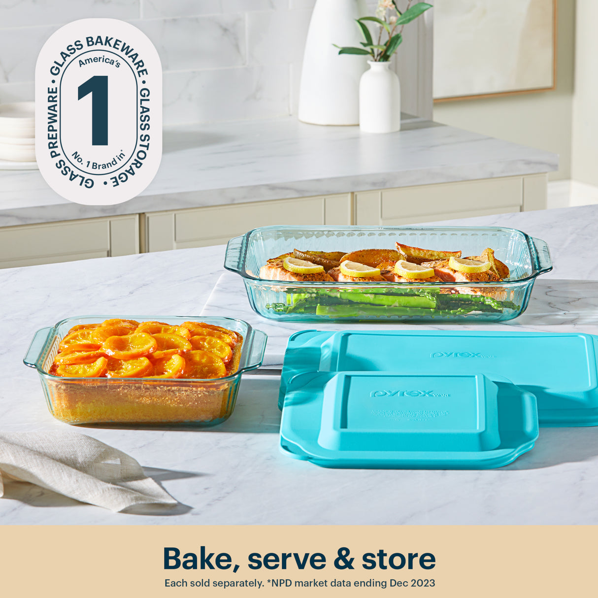 Glass bakeware set with turquoise lids on a kitchen counter, featuring the OXO brand.