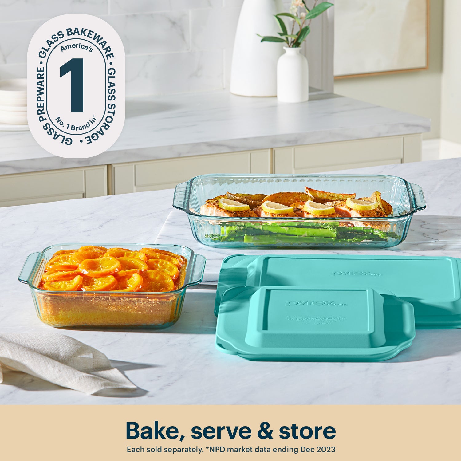 Glass bakeware set with teal lids on a kitchen counter, featuring Pyrex branding.