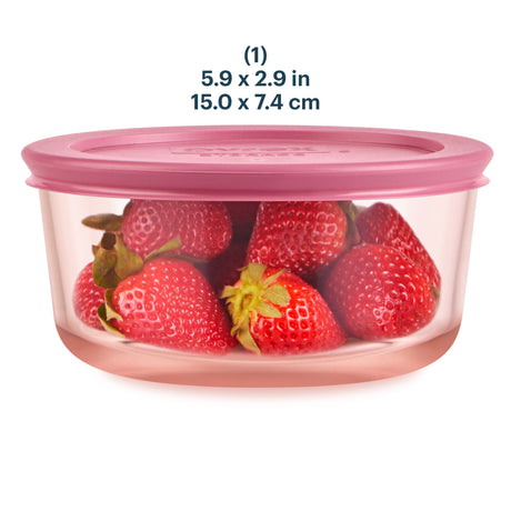Pink food storage container with strawberries inside on a white background