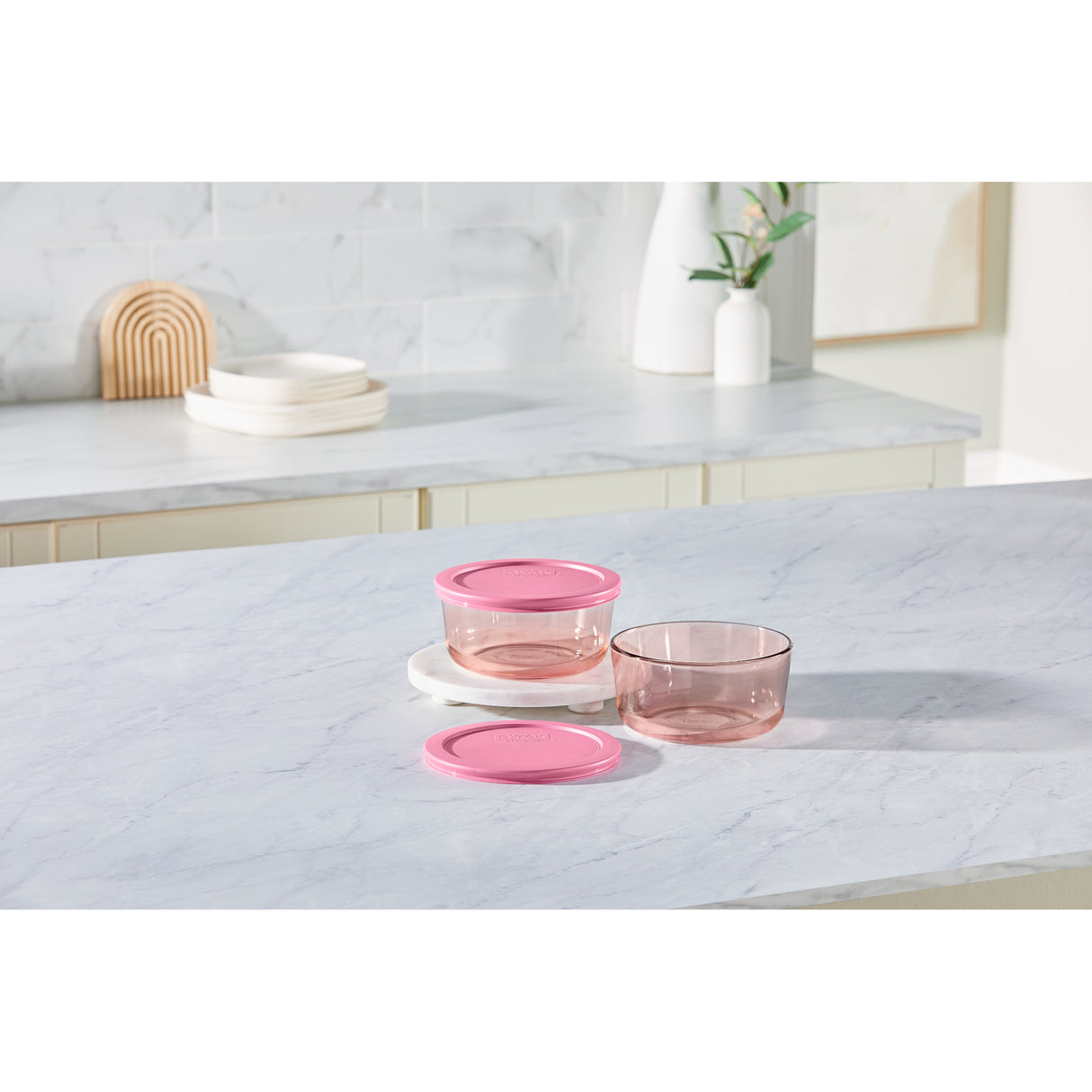 Set of pink glass bowls on a marble surface with a neutral background