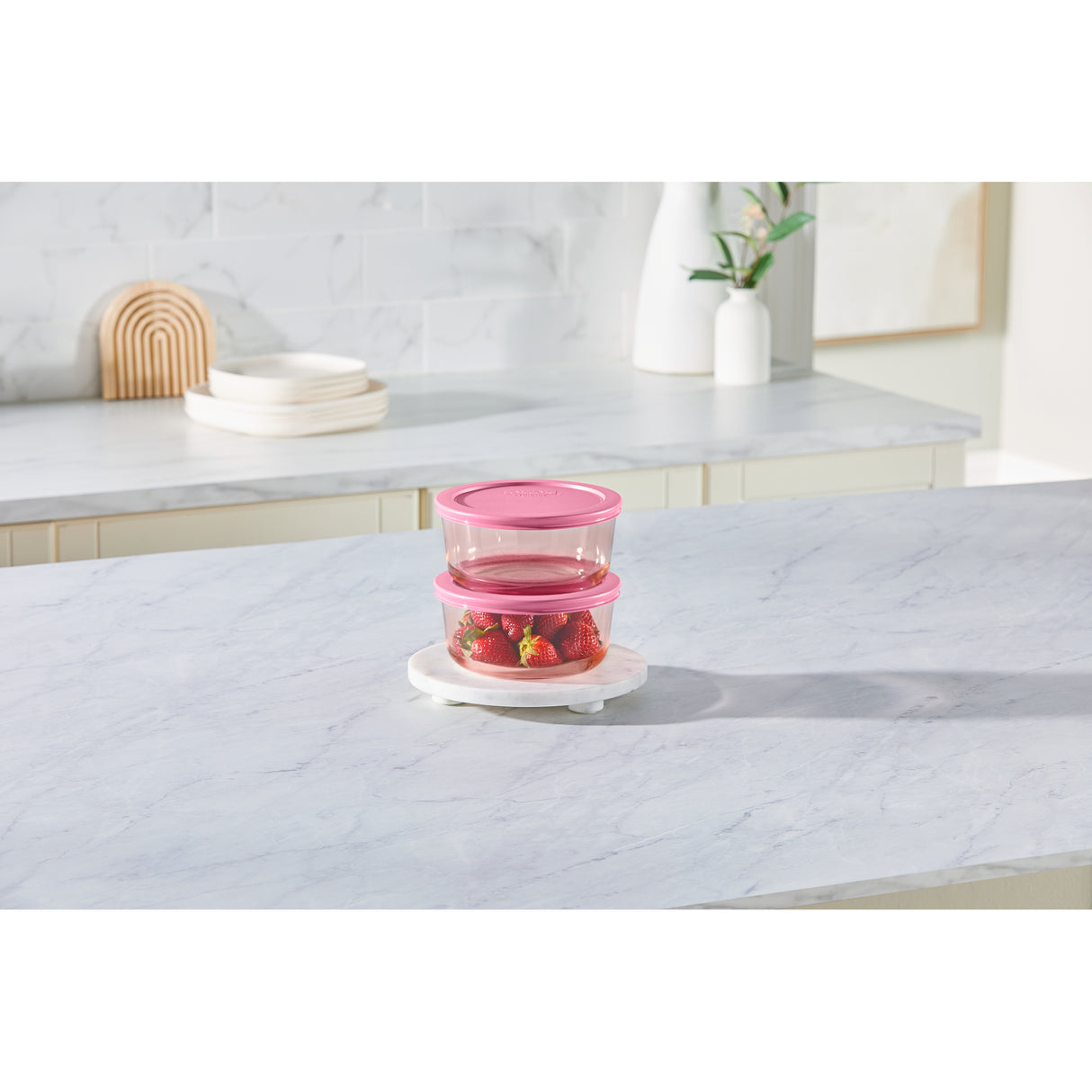 Stack of pink food containers on a marble countertop