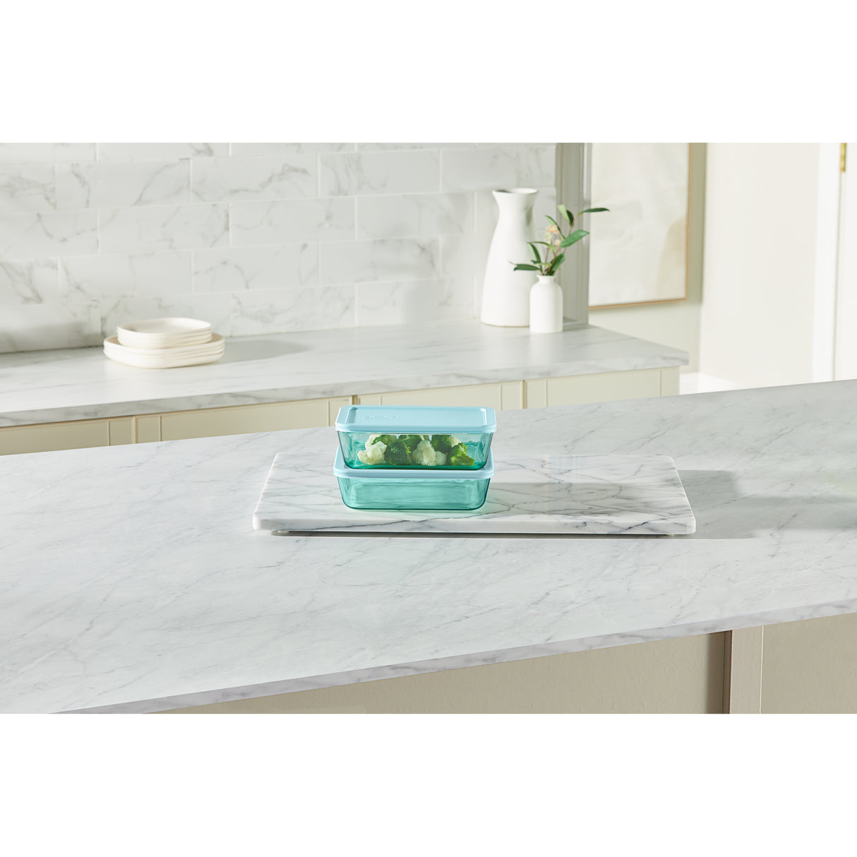 Green glass container on a marble countertop with a neutral background