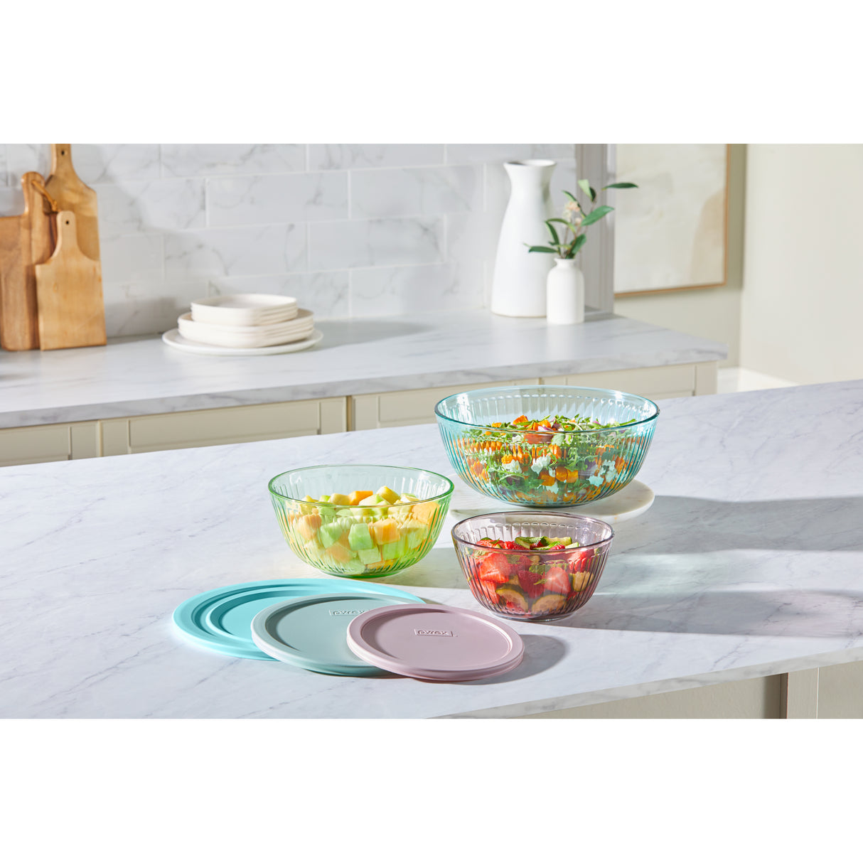 Colorful glass bowls with lids on a kitchen counter