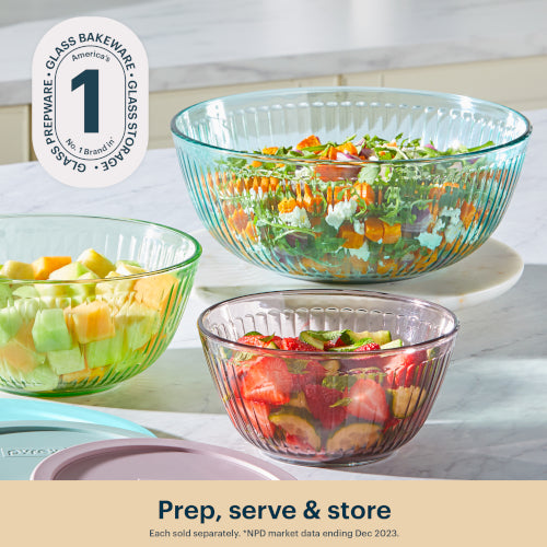 Three glass bowls containing salads on a kitchen counter with a brand logo in the corner.