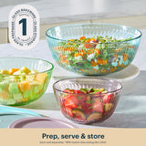 Three glass bowls containing salads on a kitchen counter with a brand logo in the corner.