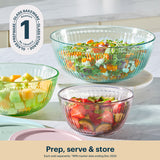 Three glass bowls with salad on a kitchen counter, featuring the Pyrex brand.