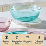 Two glass bowls, one blue and one pink, on a white surface with safety icons and text.