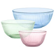 Three glass bowls in blue, green, and pink on a white background