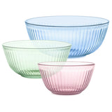 Three glass bowls in blue, green, and pink on a white background