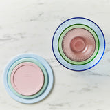 Two colorful glass plates stacked on a marble surface