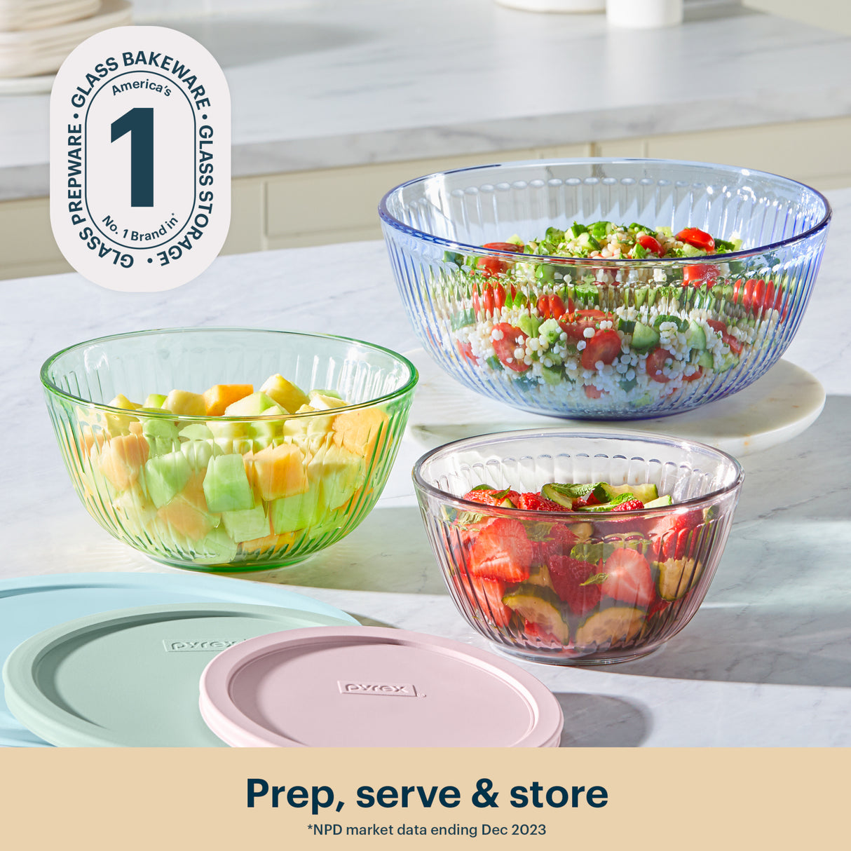 Glass bakeware bowls with colorful contents on a kitchen counter, featuring OXO branding.