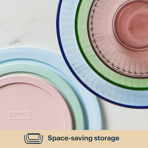 Stack of pastel-colored Pyrex dishes on a light background