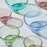 Set of colorful glass bowls on a white surface