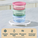 Stack of glass food containers with colorful lids on a marble surface, featuring Pyrex branding.