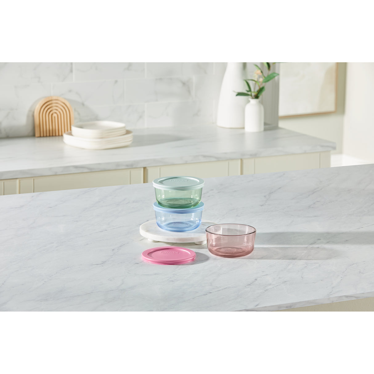 Set of colorful glass bowls on a marble countertop with a neutral background
