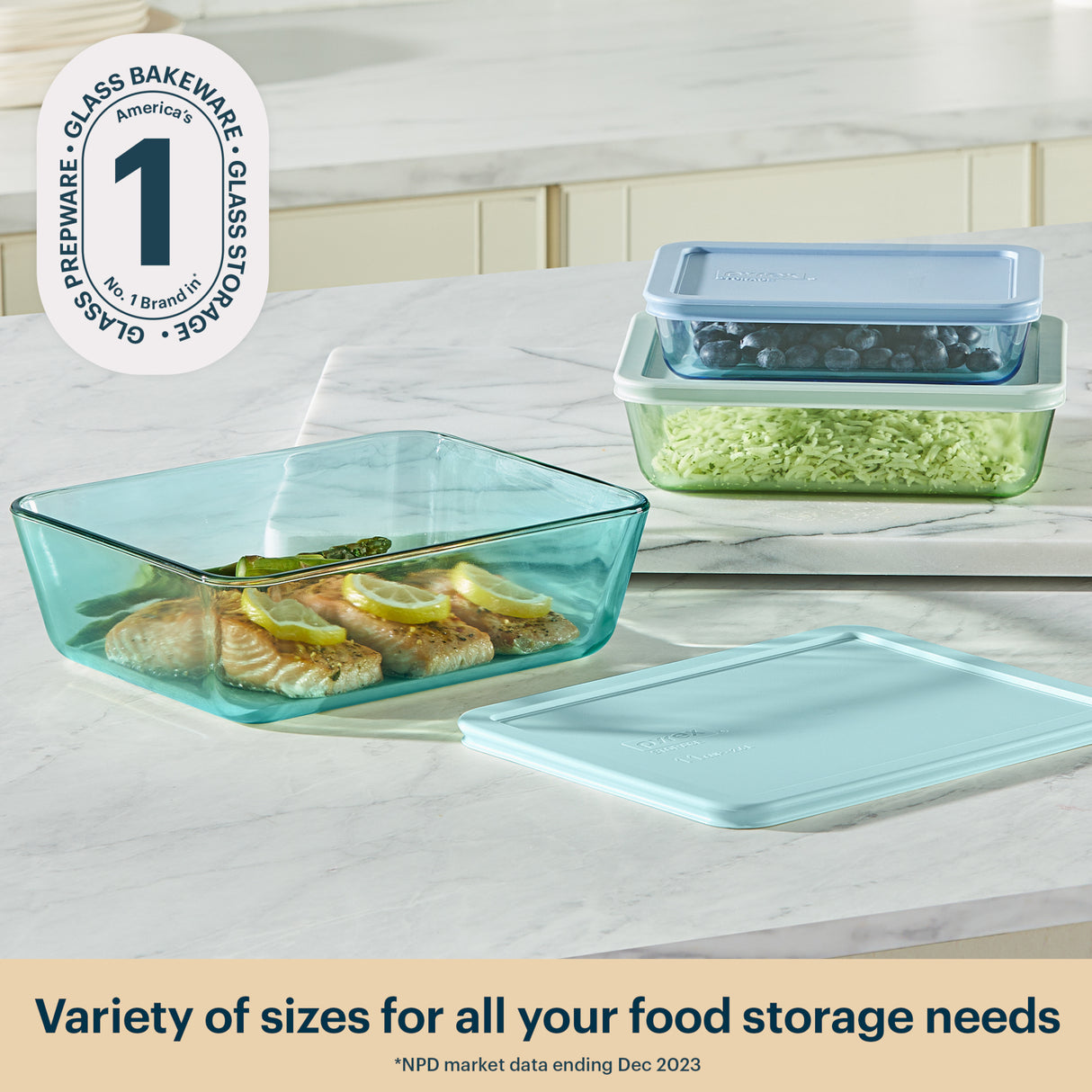 Glass food storage containers with lids on a kitchen counter, featuring the Pyrex brand.