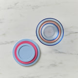 Two stackable bowls with lids on a marble surface