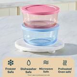Set of two stacked food storage containers with pink and blue lids on a marble stand.