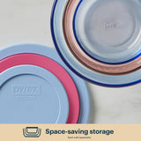 Pyrex storage containers with colorful lids on a light background