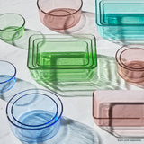 Colorful glass containers on a light surface