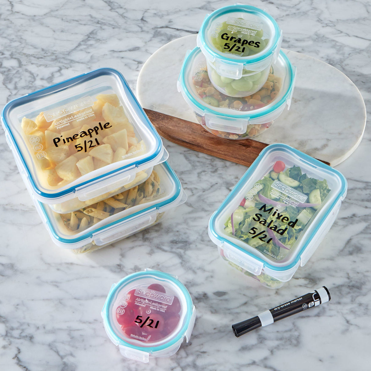 Containers with labeled lids on a marble surface, featuring text about writeable and erasable lids.
