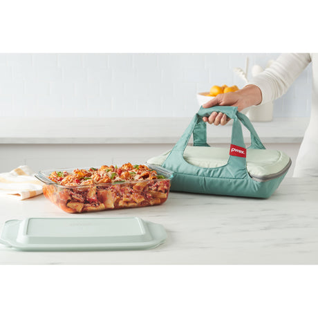 Turquoise carrying bag with a glass dish of pasta on a white surface