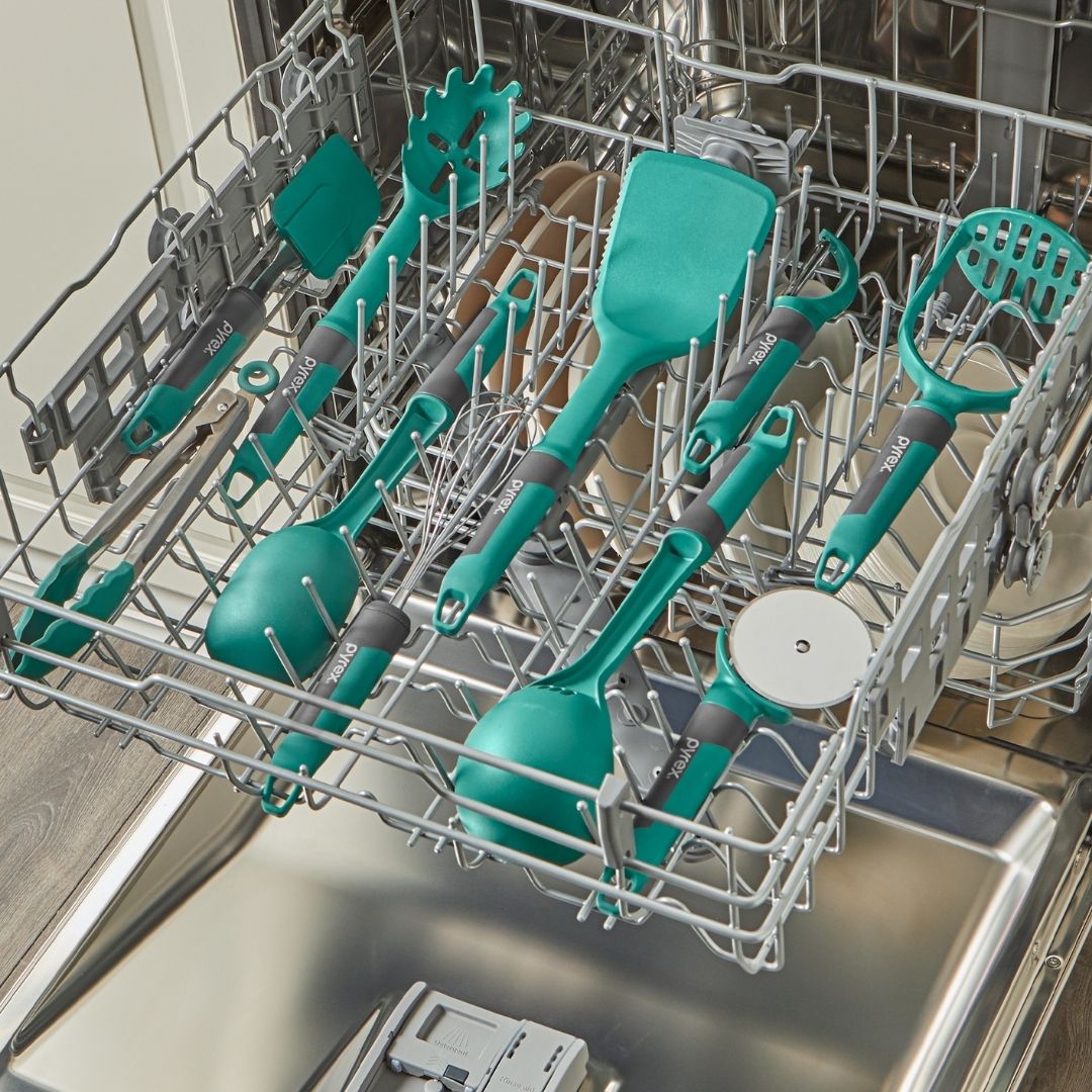 Teal kitchen utensils in a dishwasher rack