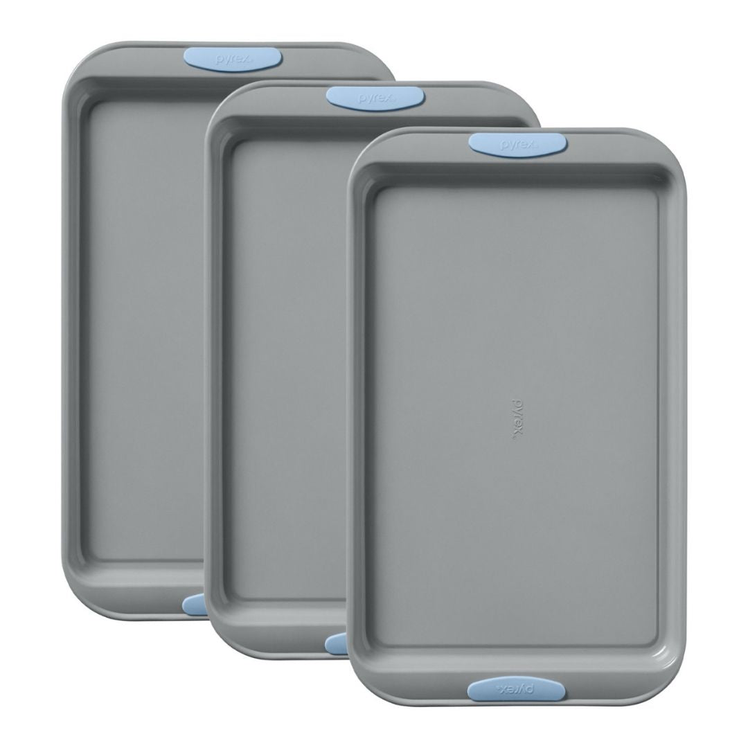 Three gray baking trays with blue silicone handles on a white background