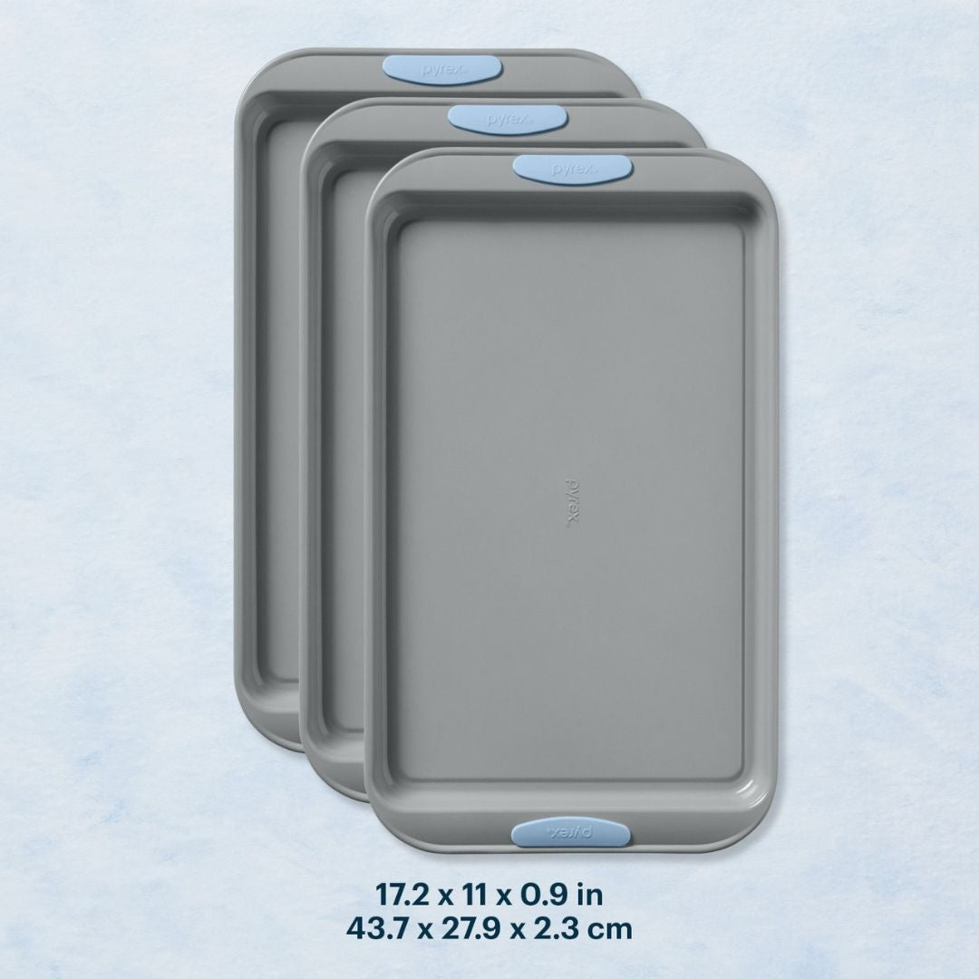 Three gray baking trays with blue handles on a light blue background