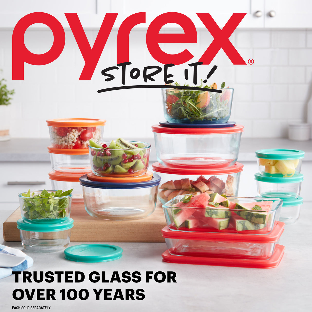 Pyrex food storage containers with colorful lids on a kitchen counter, featuring the Pyrex logo and branding.