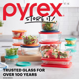 Pyrex food storage containers with colorful lids on a kitchen counter, featuring the Pyrex logo and branding.