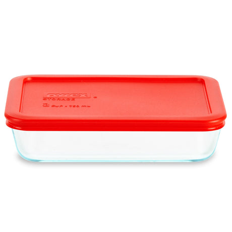 Glass food storage container with a red lid on a white background