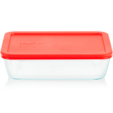 Clear glass food storage container with a red lid on a white background