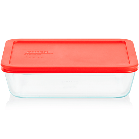 Clear glass food storage container with a red lid on a white background