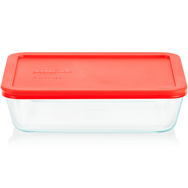 Clear glass food storage container with a red lid on a white background